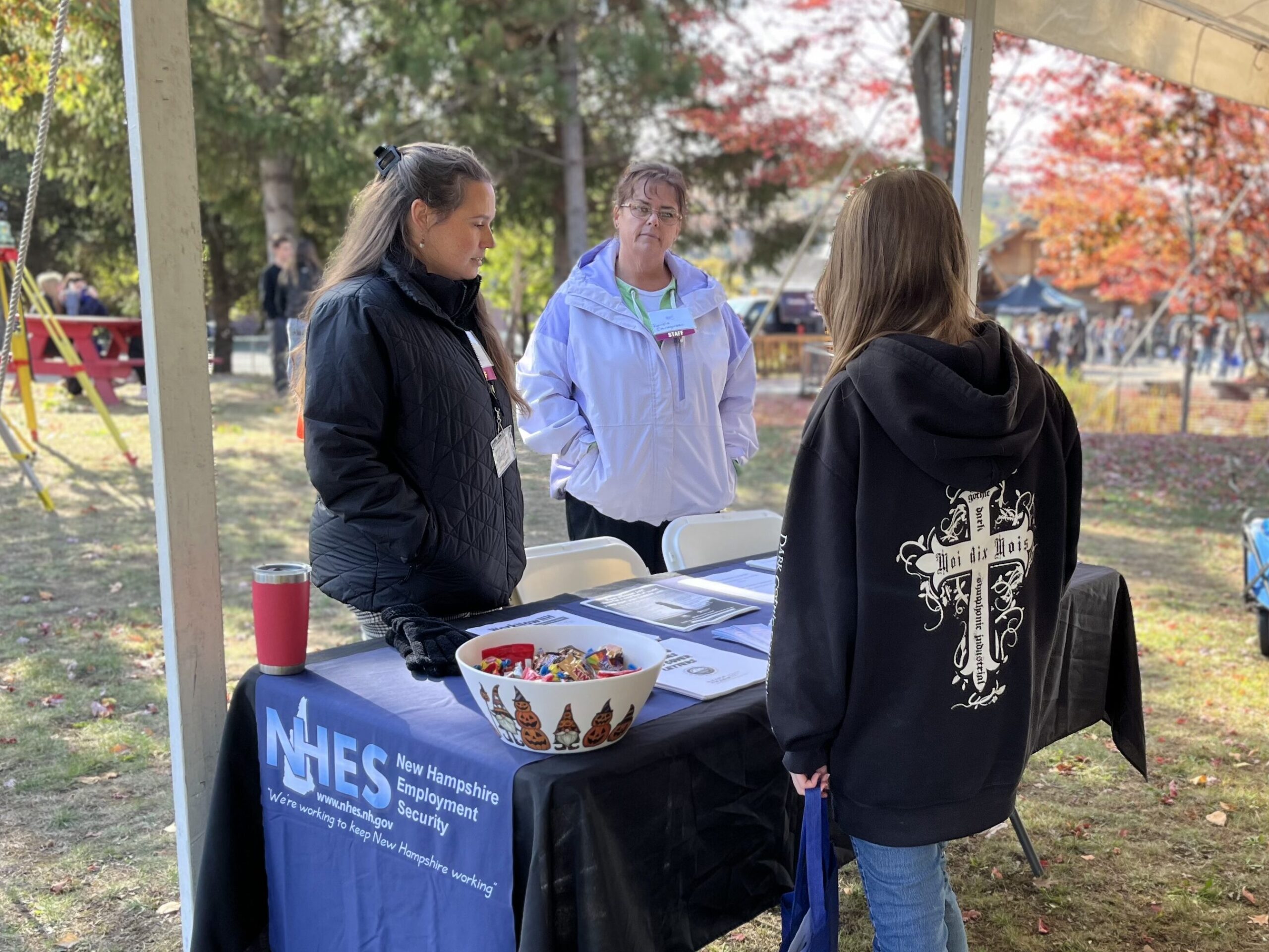 Two representatives from the New Hampshire Employment Security office talking to a student at their table.