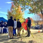 Students standing outside with land surveying equipment.